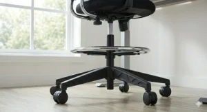 A minimalist drafting chair tucked under a standing desk, highlighting its compact and space-saving design.