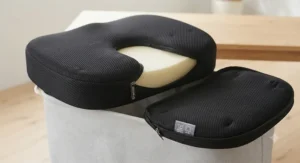 Driver using a portable coccyx cushion for lower back support during a daily commute in Canadian winter conditions.